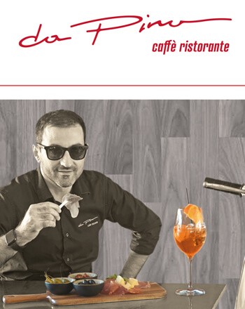Mann mit Sonnenbrille isst Schinken, Oliven, Käse auf Holzbrett und trinkt Aperol